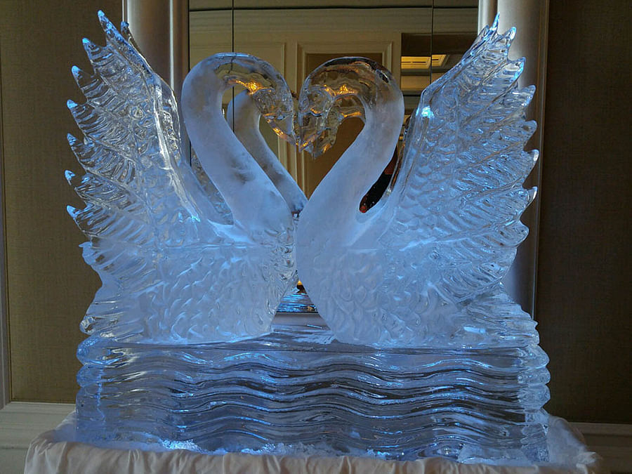 Elegant swan ice sculpture displayed at an outdoor event